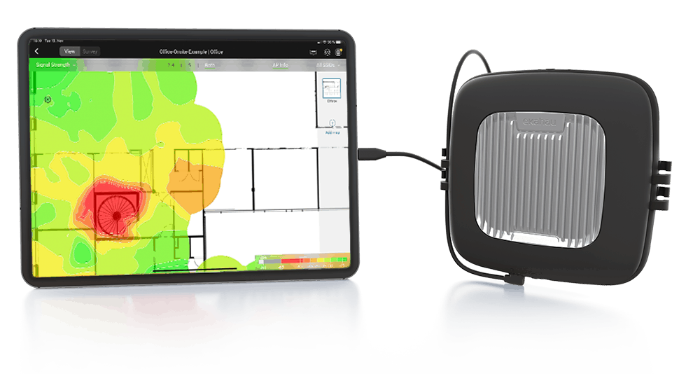 A tablet displays a color-coded floor plan heatmap for Wi-Fi analysis, connected by a cable to a square, black electronic device with a metallic center panel.