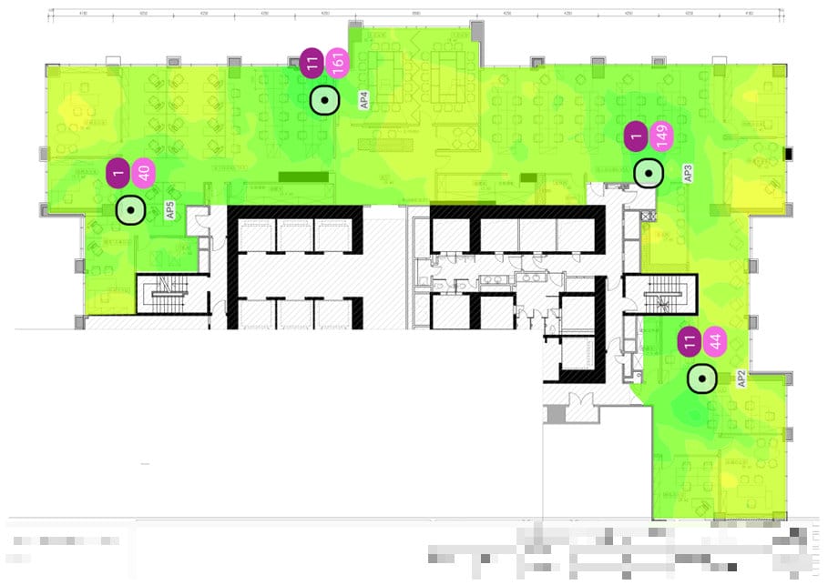 A floor plan with green and yellow shaded regions, indicating wireless signal strength from an Ekahau Site Survey, and several labeled purple and green icons throughout the layout.